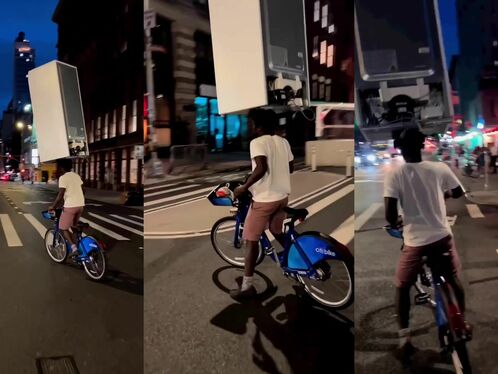 A Cyclist Carries A Refrigerator On His Head