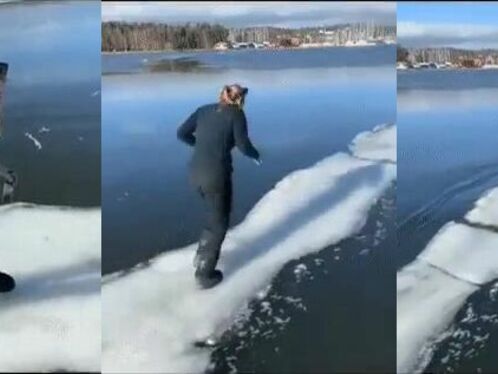Couple walks on narrow ice bridge over freezing lake