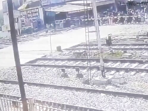 Confused Female College Student Pushing Bicycle Across Railroad Tracks