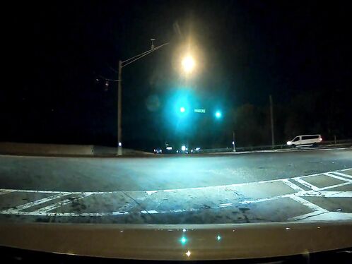 Car crashes through a street intersection at night