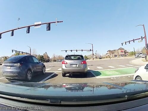 Cars try to merge into heavy traffic at busy intersection