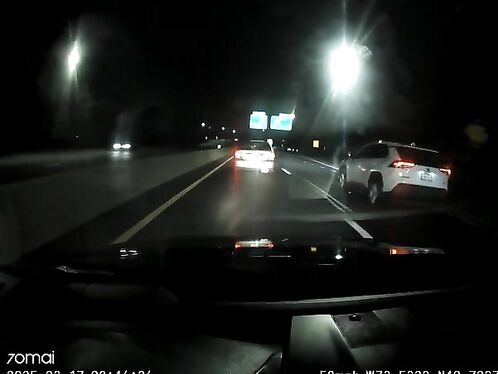 Car nearly crashes into stopped vehicles on highway
