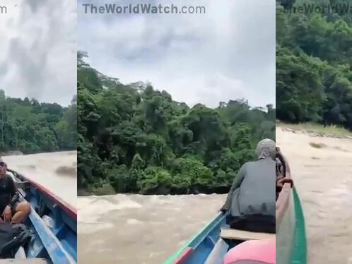 People ride through a fast flowing river on a boat