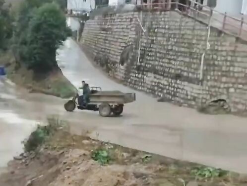Man drives three wheeled cart down flooded road