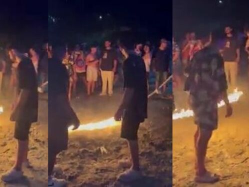 People gather around a bonfire at a party