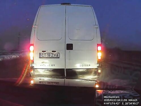 Man fixes tire on side of icy road at night