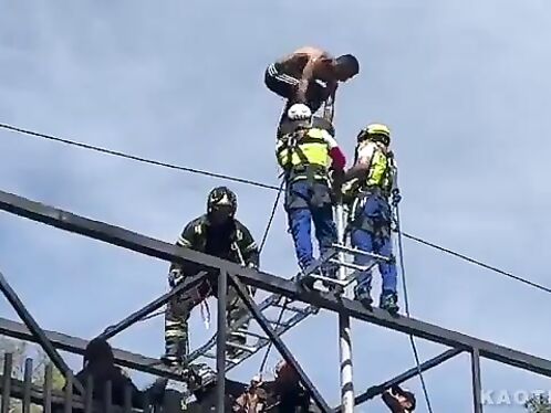 Firefighters rescue a man from a high structure