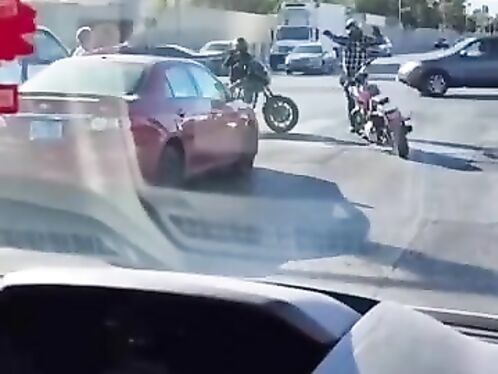 Motorcyclist gets stuck in traffic and stops in the middle of the intersection.