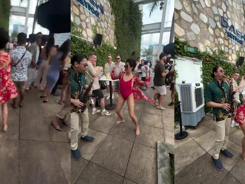 Woman dances while man plays saxophone at party