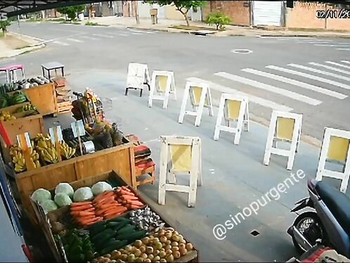 Man trips over chairs on street lined with produce
