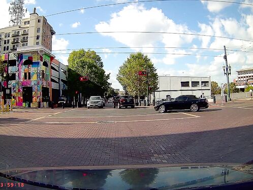 Car blows through red light at busy city intersection