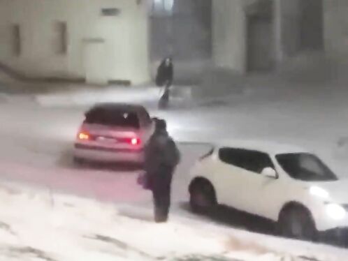 Woman struggles to walk in heavy snow storm.