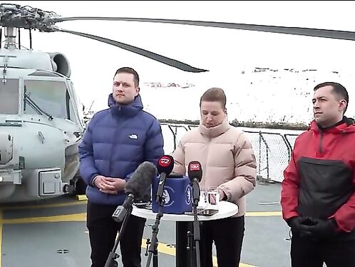 Three men give press conference in front of helicopter