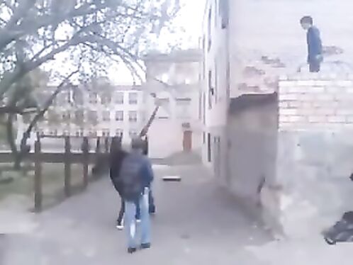Kids throw frisbee over a brick wall and retrieve it