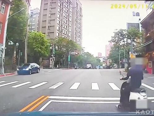 A motorcyclist crashes on a city street crossing