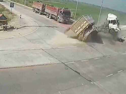 Semi truck flips over and spills load on highway