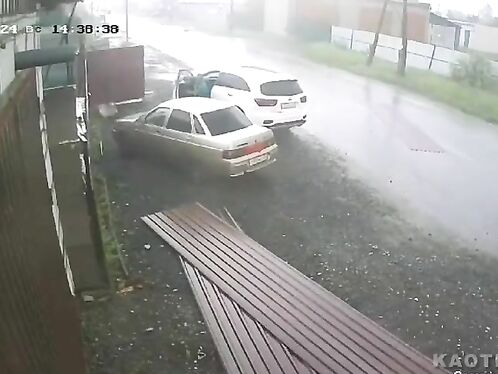 Man walks calmly while car crashes into guardrail