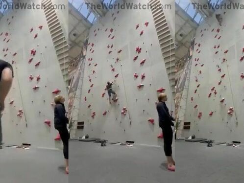 Person struggles to climb a high indoor wall