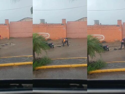 Motorcyclist falls off bike in the rain and gets soaked