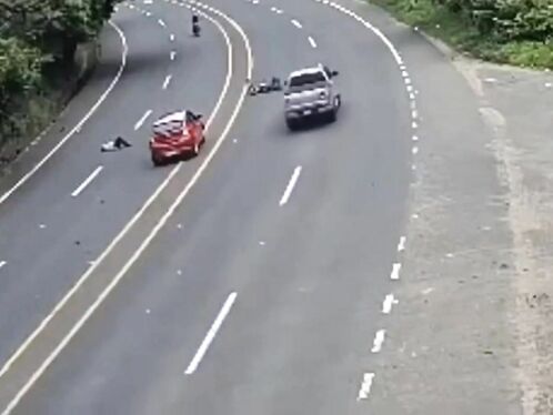 Car speeds past man lying on the highway