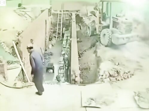 Man walks past truck that collapses into pit