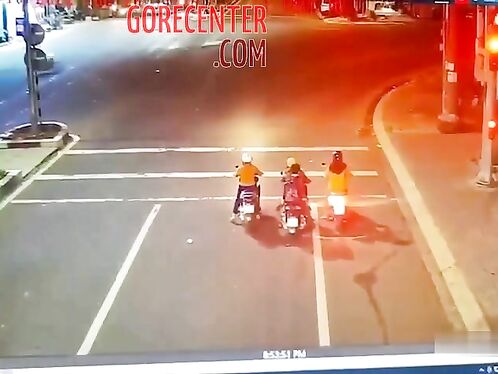 Three people on motorcycles crash at a busy intersection