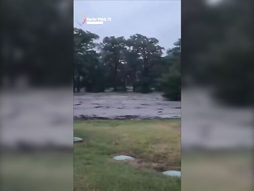 Huge wave sweeps across a flooded street