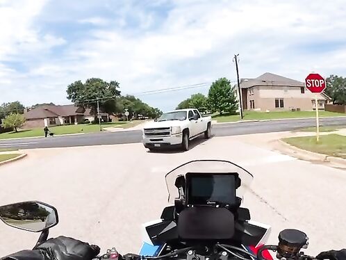 Motorcycle rider nearly runs into white truck on neighborhood street