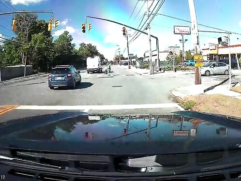 Car dashcam captures rainbow over busy intersection