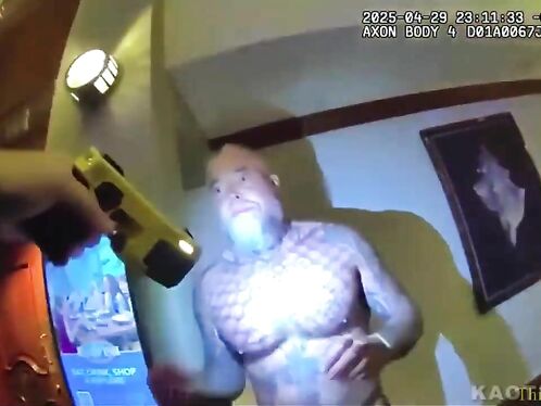 An officer apprehends a man inside a building
