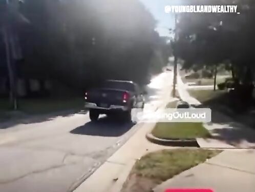 Man stands in front of moving SUV on street