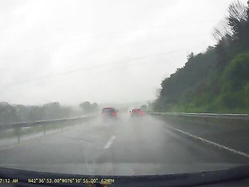 Cars navigate through heavy rain on the highway