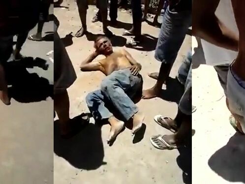 A man is being attacked by a crowd on the street