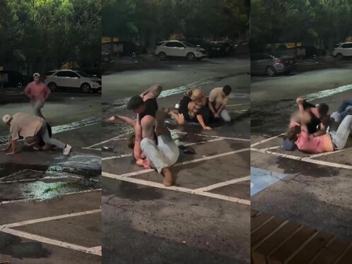 Three people fight in parking lot while others watch