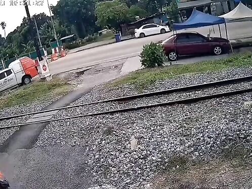 Man on motorcycle barely avoids oncoming train