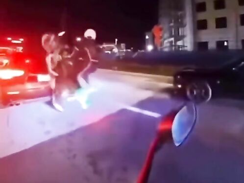 Motorcyclist crashes into police car on city street