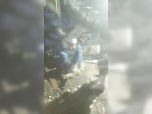 Person rummages through trash in dark alley