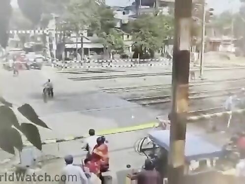 Man walks bike across train tracks for safety