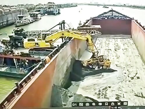 Excavator's bucket gets stuck and fails to lift dirt to the ship