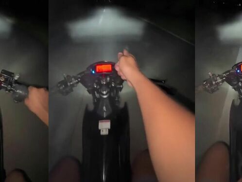 Rider drives motorcycle in pitch black rain