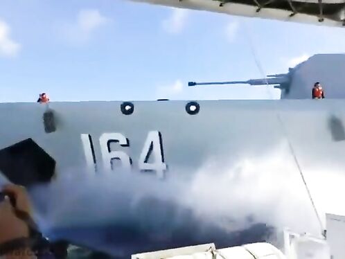Crew member struggles with rope on military ship