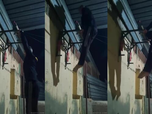 Person struggles to pull up on a bar in a dark alley