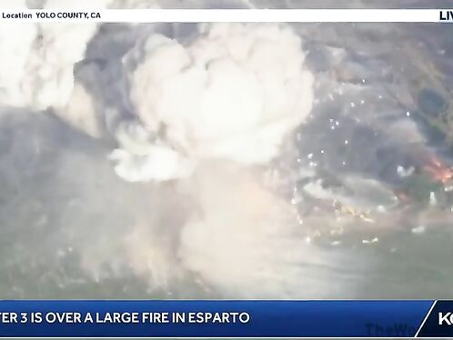 Helicopter surveys smoldering debris from fiery crash