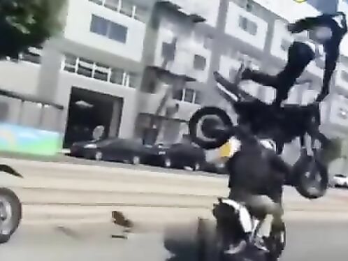 Bikers flip their motorcycles in a street stunt showdown