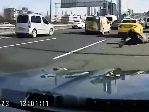 Motorcyclist crashes in front of car on busy highway