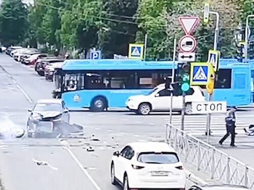 Car crashes into a pedestrian and a bus in a busy intersection