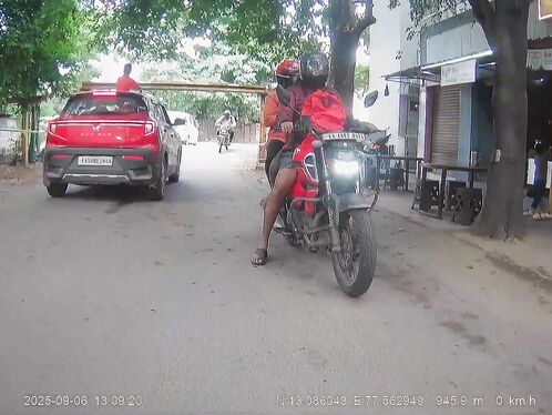 Man rides on top of a red compact car