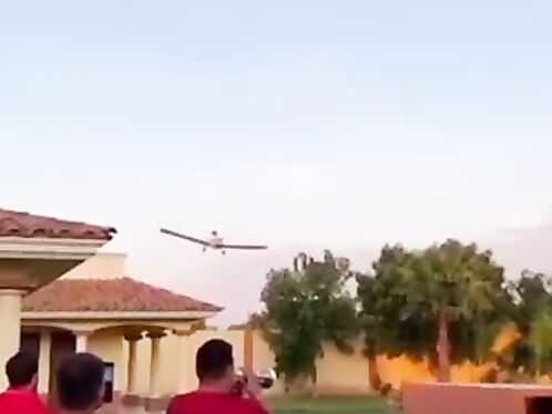 Plane stunts with smoke trails in neighborhood